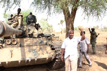 SPLM-N SG poses with SPLA-N fighters riding a tank during a recent visit to South Kordofan in March 2016 (ST Photo)