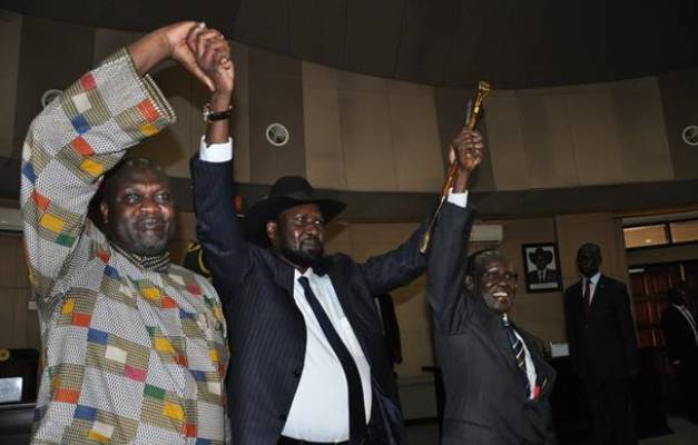 President Salva kiir(C) FVP; Riek Machar (L), and VP, Marilyn, raise their hands after swearing in ceremony of Machar on April 26, 2016. (Photo Lomayat Moses)