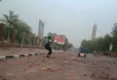 A student throws stones during a confrontation with the police outside the University of Khartoum on Wednesday April 13, 2016