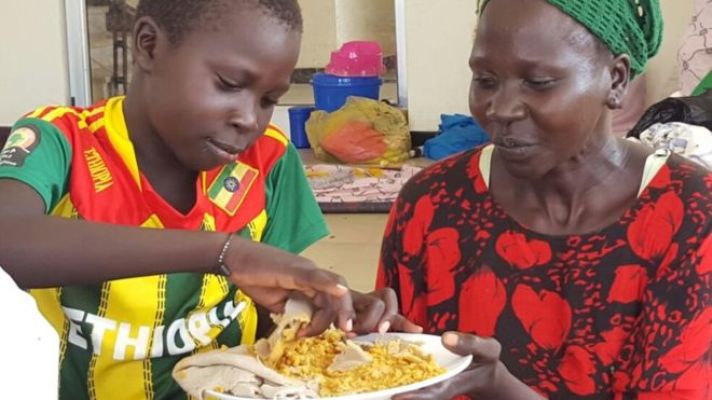Ethiopian Nuer child, Jany, eating with his mother after he was rescued from Murle abductors (BBC photo)