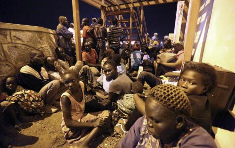 In this photo taken late Friday, July 8, 2016 and released by the UNMISS, villagers huddle for safety from the fighting between buildings near the UN base and compound in Juba (AP Photo)