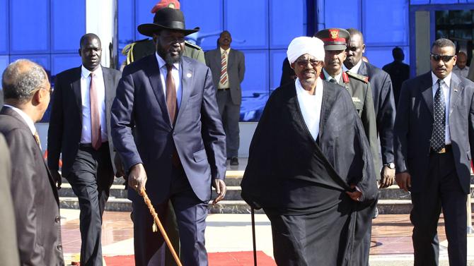 Omer al-Bashir (R) walks with  Salva Kiir after their meeting at Khartoum's airport November 4, 2014 (Reuters Photo)