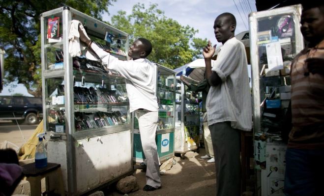 A mobile phone vendor from Cameroon prepares for a day of business in Juba, South Sudan (AP Photo)