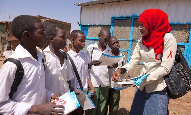 Peer educator Arafat speaks with a group of school children and distribute HIV-AIDS awareness materials, in a community in Khartoum, Sudan (UNICEF SUDAN Photo)