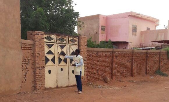SCoP activist knocking on the door of a family house in the suburb of Jabal Awliya, south of Khartoum on 30 September (ST Photo)