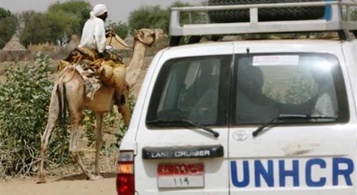 UNHCR convoy passes Sudanese man riding on a camel, Um Shalaya refugee camp south of the Darfur town of Al-Geneina,on April 25, 2007 (AP Photo)