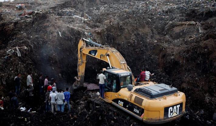 Rescue workers watch as excavators dig into a pile of garbage in search of missing people following a landslide when a mound of trash collapsed on an informal settlement at the Koshe garbage dump in Ethiopia's capital Addis Ababa. (Reuters/Tiksa Negeri)