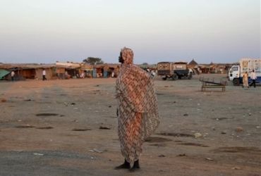 An unidentified woman stands in the central market of Abyei, Sudan, Thursday Jan. 13, 2011,