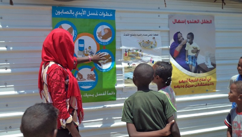 A UNICEF trained health worker walks children through he correct steps of hand washing with soap in February 2016 (UNICEF Sudan Photo)