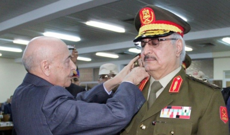 A Libyan official adjusts a rank to the uniform of the anti-Islamist General Khalifa Haftar (R) during his swearing in ceremony as the new army chief in the eastern city of Tobruk on March 9, 2015 (AFP)