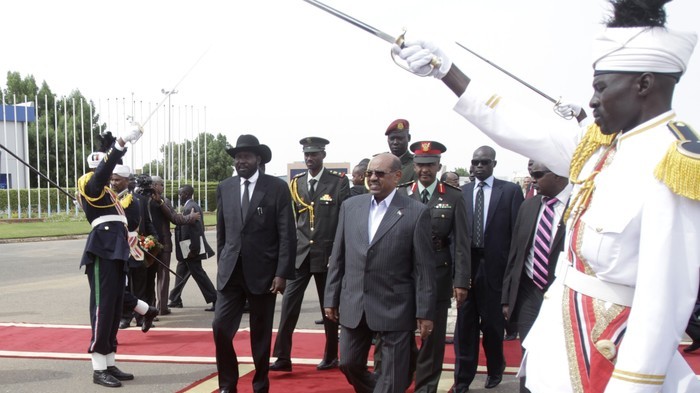 President Omer al-Bashir (C-R) walks alongside his South Sudan's counterpart Salva Kiir (C-L) upon his arrival at Khartoum airport on Sept 3, 2013 (Photo AFP)