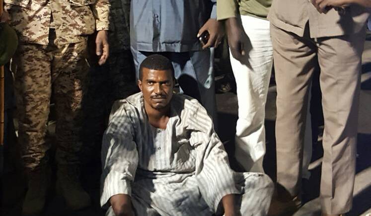 Surrounded by army and security officers rebel leader Ali Rizkallah sits on the ground after getting off the plane at Khartoum airport as he is unable to stand up due an injury to his leg on Saturday 11 November 2017 (ST Photo)