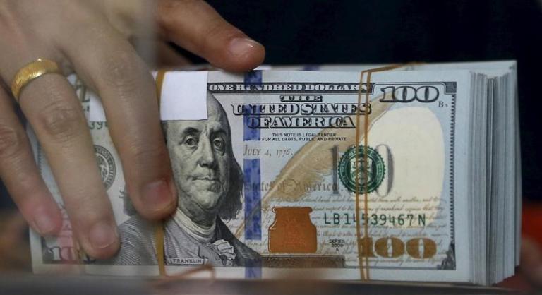 An employee of a money changer holds a stack of U.S. Dollar notes before giving it to a customer in Jakarta, October 8, 2015. (Reuters Photo)