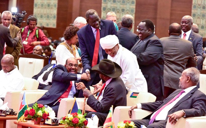 Omer al- ashir laughing with Kiir and shakes hands with Deng Alor after the signing of the governance agreement on 5 August 2018 (Photo Ugandan presidency)