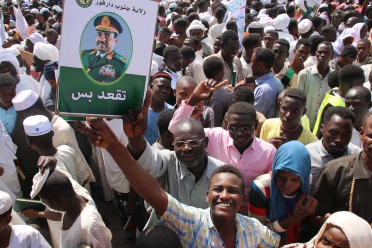 Al-Bashir supporter holds a banner saying