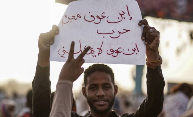 A protester hold a banner saying al-Bashir is war criminal, he does not represent me on 11 April 2019 (ST Photo)