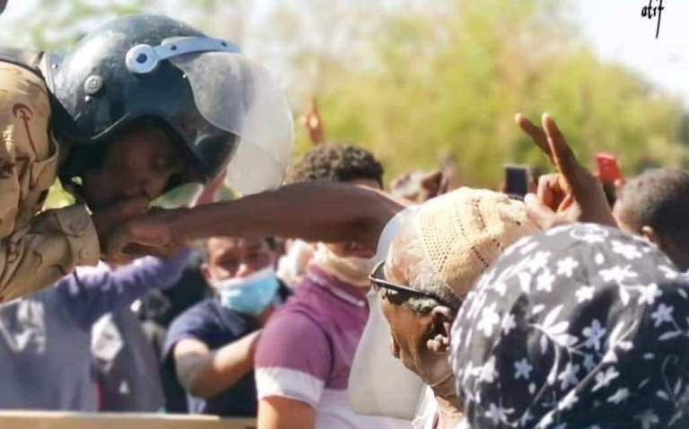 Sudanese army soldier kissing the hand of an elder who takes part in the sit-in outside the army headquarters on 8 April 2019 (ST Photo)