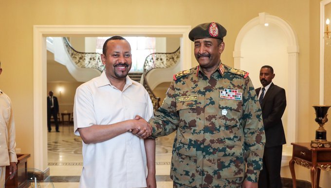 Ethiopia's Abiy Ahmed (L) shakes hand with Sudan's TMC leader Abdel Fattah al-Burhan on 7 June 2019 (SUNA photo)