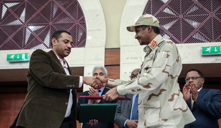 Ahmad al-Rabiah,(L), FFC representative and Mohamed Hamdan, the TMC deputy leader, after shake hands after initialling a power-sharing deal in Khartoum, Sudan, on 17 July 2019.(Photo Mahmoud Hjaj-AP)