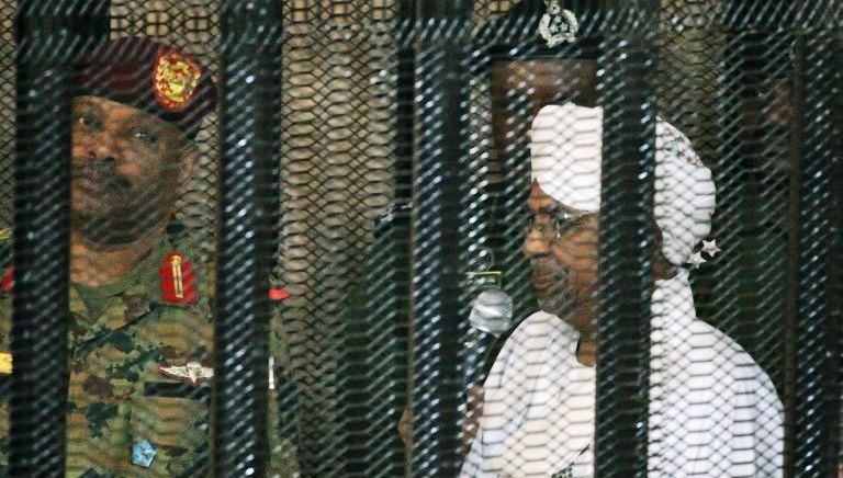 Sudan's deposed military ruler Omar al-Bashir stands in the defendant's cage during the opening of his corruption trial in Khartoum on 19 August 2019 (AFP Photo)