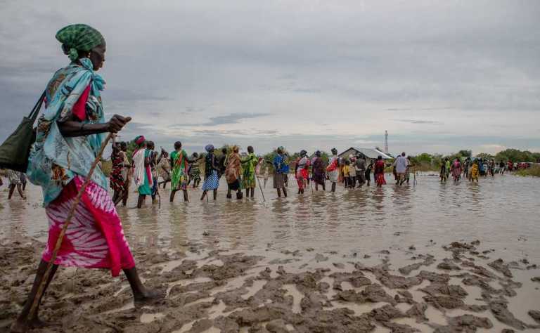 Communities make their way back to their temporary housing through flood water after distribution points run out of supplies, in Pibor, Boma State, South Sudan, on 6 November 2019 (UNICEF South Sudan)