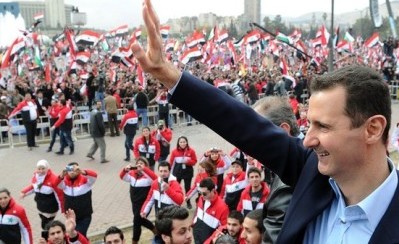 الرئيس الاسد يلوح لمؤيده الذين خرجوا في مظاهرة تاييدا له في دمشق في 11 يناير 2012