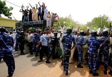 sudanese_policemen_try_to_restrain_protesters_demonstrating_against_an_amateur_film_mocking_islam_following_friday_prayers_outside_the_grand_mosque_in_khartoum_on_september_14_2012.getty.jpg