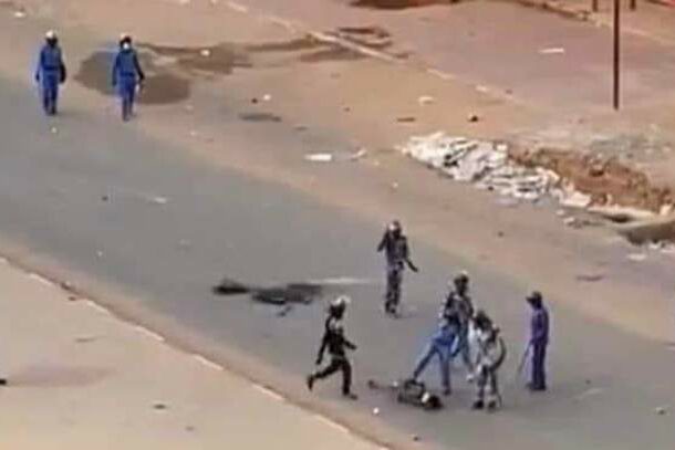 Policeman kicks with his shoes a dead proteter