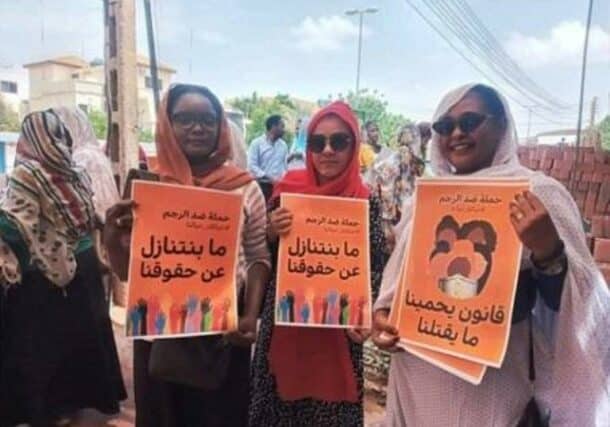 Sudanese women hold banners calling to abolish stoning sentence outside UNHCR in Khartoum on September 14, 2022