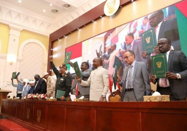 Sudan's political and military leaders hold up the signed framework agreement on December 5, 2022