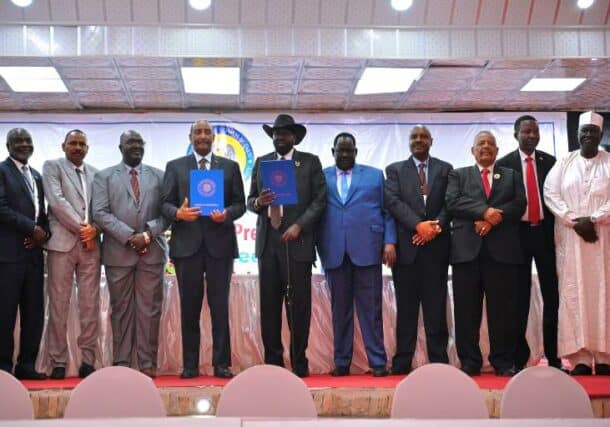 Al-Burhan and Kiir hold the new implementation matrix of Juba peace agreement in a pose with the signatories on February 19, 2023
