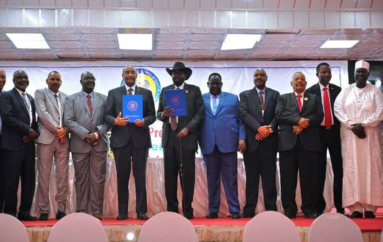 Al-Burhan and Kiir hold the new implementation matrix of Juba peace agreement in a pose with the signatories on February 19, 2023