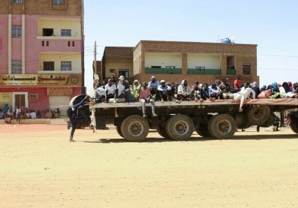 People fleeing street battles between the forces of two rival Sudanese generals, are transported on the back of a truck in the southern part of Khartoum, on April 21, 2023 AFP