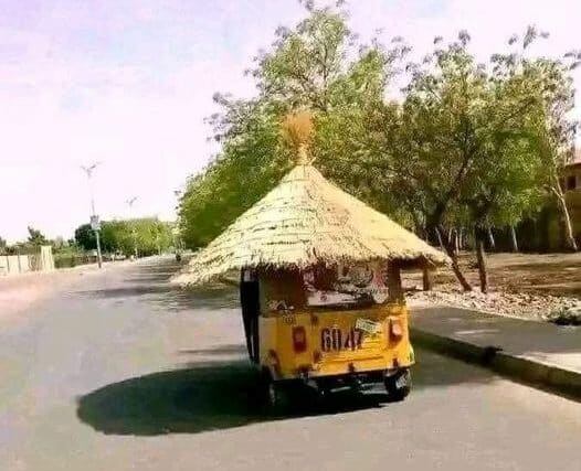 A ragsha driver on a street in Juba places a straw cover on his vehicle to reduce the temperature