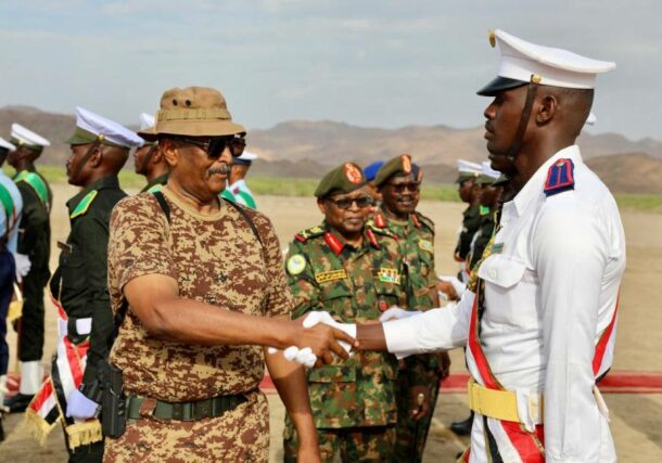 Al Burhan shakes hands with a graduated army officer in Gebit on July 31, 2024