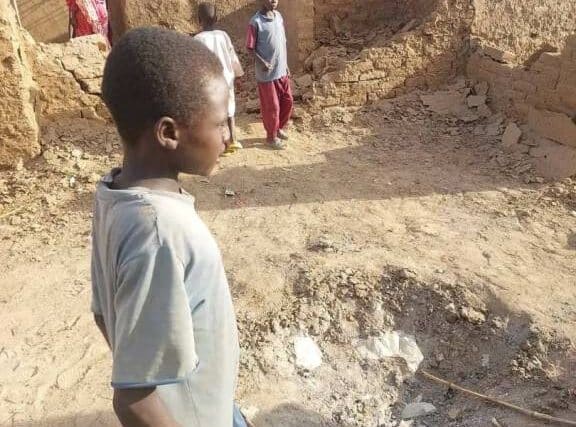 child stands near the impact zone of an RSF projectile, following an artillery attack on Abu Sock camp on August 12, 2024.