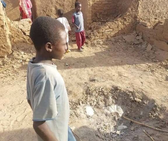 child stands near the impact zone of an RSF projectile, following an artillery attack on Abu Sock camp on August 12, 2024.