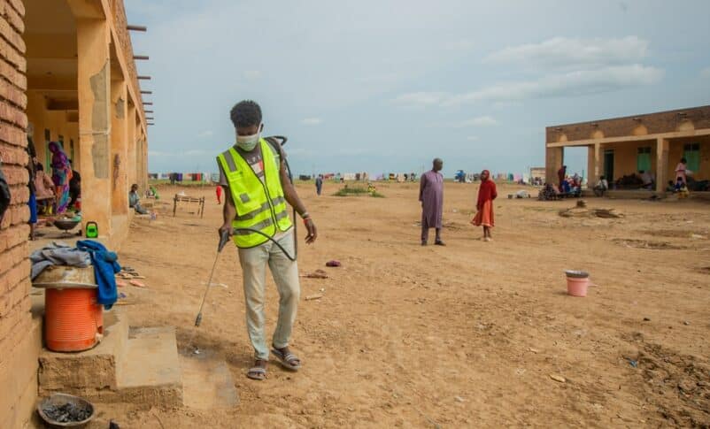 A volunteer sprays the compound and spaces at Alashpal gathering point for displaced persons in West Kassala locality on September 3, 2024 (UNICEF photo)