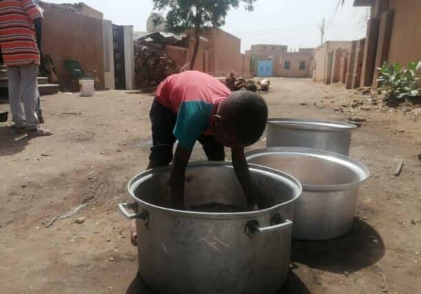 A young boy in Shambat, Khartoum Bahri, helps in a charity Kitchen to prepare a meal for the residents, on November 10, 2023
