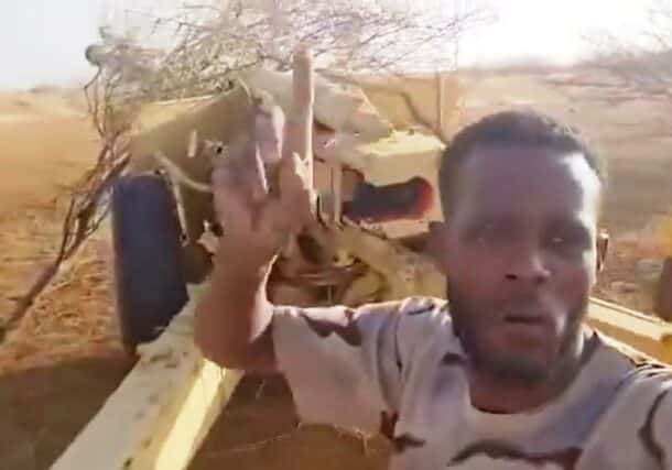 An RSF fighter poses with a 130mm M46 howitzer, vowing to shell El Fasher on May 21, 2024