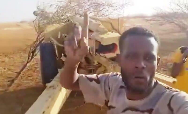An RSF fighter poses with a 130mm M46 howitzer, vowing to shell El Fasher on May 21, 2024