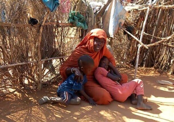 A woman and her two children in Zamzam camp, where she has sought shelter after fleeing attacks by the RSF in North Darfur. (AFP file photo)