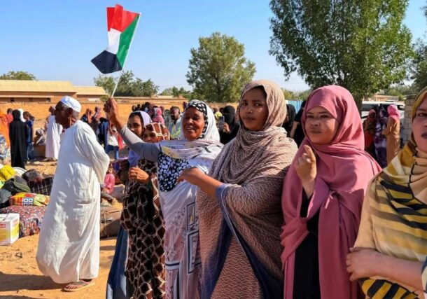 A woman holds the Sudanese flag as IDPs return to Wad Madani in Al Jazirah state, on February 6, 2025 AFP photo