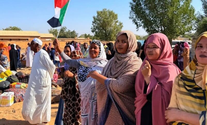 A woman holds the Sudanese flag as IDPs return to Wad Madani in Al Jazirah state, on February 6, 2025 AFP photo
