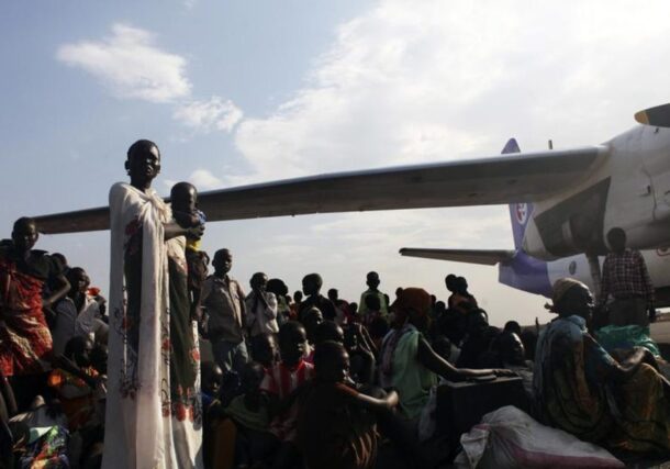 People, displaced by the recent fighting in Malakal, wait as they try to get on an airplane to Juba, at the airport in Paloch, Upper Nile State, March 2, 2014. REUTERS