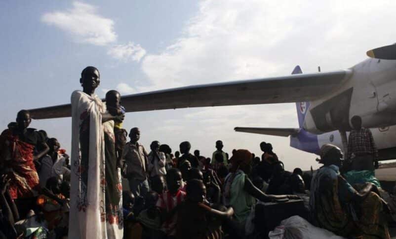 People, displaced by the recent fighting in Malakal, wait as they try to get on an airplane to Juba, at the airport in Paloch, Upper Nile State, March 2, 2014. REUTERS