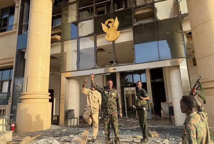 Sudanese army members raise their hands after the recapture of the presidential palace on March 21, 2025