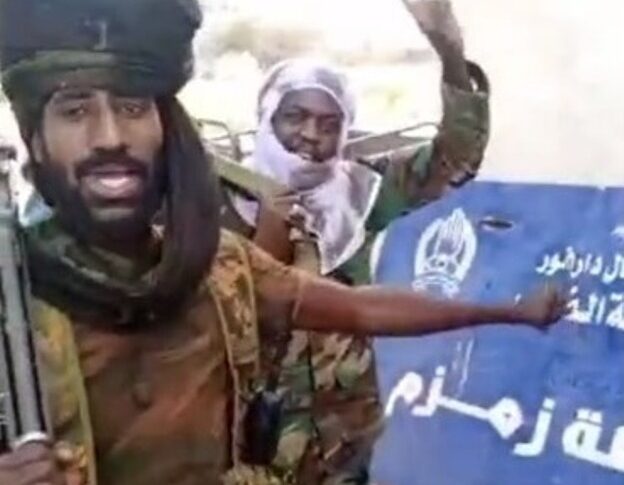 RSF fighters point to the police station sign at Zamzam camp after taking control of the area, North Darfur, April 13, 2025.