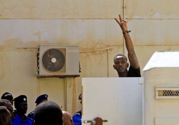 Mohamed Adam Tupac get out of a car to attend his trial at a court in Khartoum, file photo