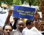 A Sudanese journalist holds a banner reading, "To be a journalist is not a crime," in this file photo.